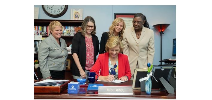 Dr. Rose Mince, President of Carroll Community College, signs the lease agreement with Coppermine Pantherplex for the new Ratcliffe Applied Technology and Trades Center as members of the Carroll Community College Executive Team look on.